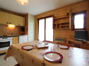una cocina con una mesa con platos. en Appartement Lanslevillard, 2 pièces, 4 personnes - FR-1-508-209, en Lanslevillard