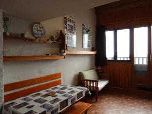 a bedroom with a bed and a chair and a window at Appartement Aussois, 2 pièces, 4 personnes - FR-1-508-157 in Aussois