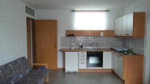 eine kleine Küche mit einem Sofa in einem Zimmer in der Unterkunft Appartementhaus Lang in Mörbisch am See