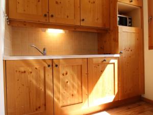 een keuken met houten kasten en een wastafel bij Appartement Lanslebourg-Mont-Cenis, 2 pièces, 4 personnes - FR-1-508-149 in Lanslebourg-Mont-Cenis