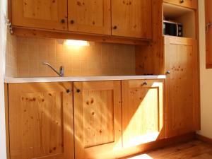 a kitchen with wooden cabinets and a sink at Appartement Lanslebourg-Mont-Cenis, 2 pièces, 4 personnes - FR-1-508-149 in Lanslebourg-Mont-Cenis