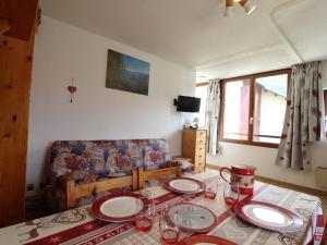 a living room with a table with plates on it at Studio Lanslevillard, 1 pièce, 4 personnes - FR-1-508-155 in Lanslevillard