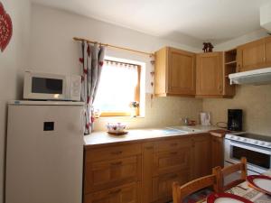 a kitchen with a white refrigerator and a window at Studio Lanslevillard, 1 pièce, 4 personnes - FR-1-508-155 in Lanslevillard