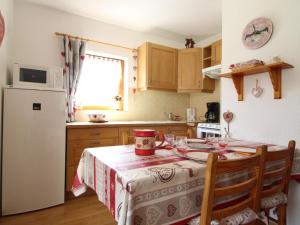 a kitchen with a table and a white refrigerator at Studio Lanslevillard, 1 pièce, 4 personnes - FR-1-508-155 in Lanslevillard