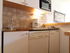 a small kitchen with a sink and a microwave at Appartement 4 personnes avec balcon au pied des pistes - Résidence à Val-Cenis - FR-1-508-160 in Lanslevillard
