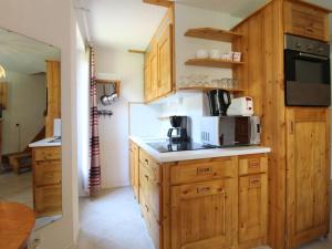 a kitchen with wooden cabinets and a counter top at Appartement Lanslevillard, 2 pièces, 5 personnes - FR-1-508-215 in Lanslevillard