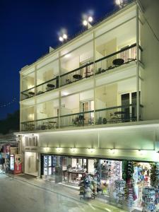a large white building with a store front at night at Adrian Hotel in Athens