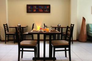 uma sala de jantar com duas mesas e cadeiras com comida em Costa Dourada Pousada em Arraial do Cabo