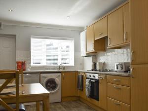 uma cozinha com uma máquina de lavar roupa e uma máquina de lavar roupa em Pier View em Gorleston-on-Sea