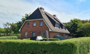 a large brick house with a gambrel roof at Wohnung Ankerplatz in Wrixum