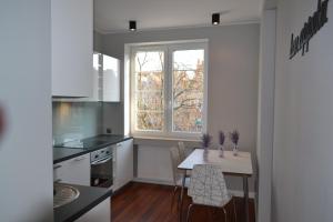 cocina con mesa, sillas y ventana en Apartamenty na Starówce Grobla en Gdansk