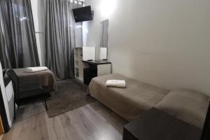 a hotel room with two beds and a television at Guest House Minas in Milan