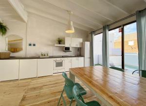 cocina grande con mesa de madera y sillas en Casa Aquamarine, en Barcelona