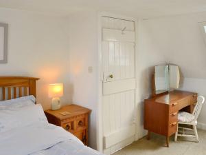 a bedroom with a bed and a desk and a mirror at Beul-an-latha in Saint Abbs