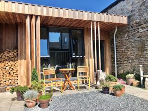 a patio with a table and chairs and a building at Archavon Luxury Studio in St Just