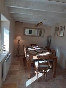 a dining room with a wooden table and chairs at Alma Bella in Le Péage +10 photos