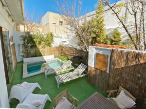 un patio trasero con piscina, sillas y una valla en Casa Lavander, en Barcelona