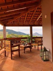 a porch with benches and a view of the mountains at Pousada Villa Paraizo in Ribeirão Claro