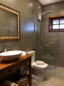 a bathroom with a sink and a toilet and a shower at Pousada Villa Paraizo in Ribeirão Claro