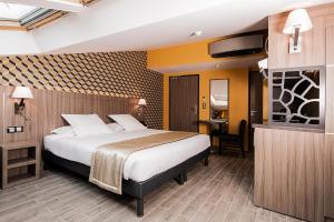 サン・ラファエルにあるUnique Hôtel & Spaのベッドとテレビが備わるホテルルームです。