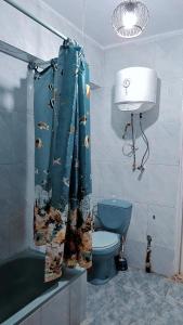La salle de bains est pourvue de toilettes bleues et d'un rideau de douche. dans l'établissement Star House City Stars, au Caire
