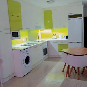 cocina con electrodomésticos blancos y mesa de madera en Apartamento Izaña, en San Isidro