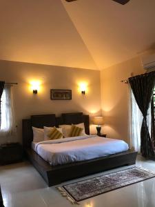 una camera da letto con un grande letto con lenzuola bianche di Villa Wodeyarmutt Tropical luxury living a Sringeri