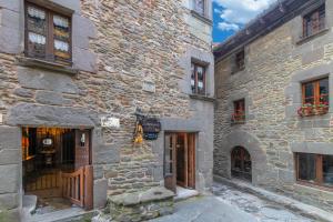 un antiguo edificio de piedra con puertas y ventanas en Apartamento Can Lo 3, en Rupit