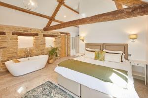 a bedroom with a large bed and a bath tub at The Irishman's Cottage in Yedingham