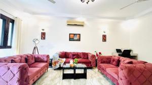 a living room with two red couches and a table at Olive Serviced Apartments - Defence Colony in New Delhi