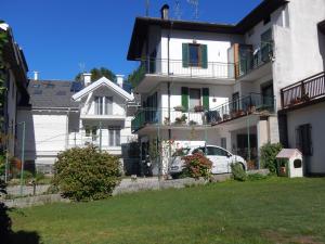 uma casa branca com um carro estacionado em frente dela em La Coccola di Giovanni em Levico Terme