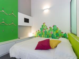 a bedroom with a white bed with a cactus wall at Central Rooms Il Re in Catania +11 photos