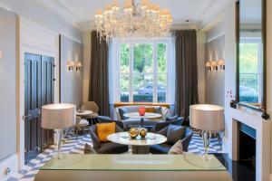a living room with couches and a chandelier at Eccleston Square Hotel in London