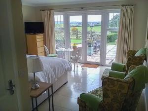 - une chambre avec un lit, des chaises et un balcon dans l'établissement Studio Quercus, à Todenham
