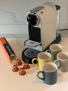 a toaster and cups of coffee on a table at RECENTLY RENOVATED property in the heart of Southwell in Southwell