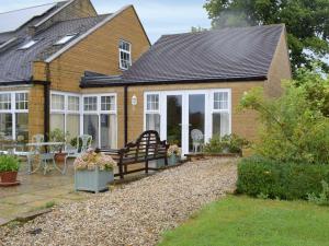 a house with a bench in front of it at Studio Quercus in Todenham