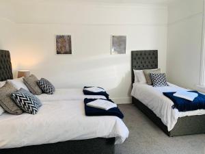 - 2 lits avec des oreillers dans une chambre dans l'établissement 4 bedroom House nr Cardiff City Centre, à Cardiff
