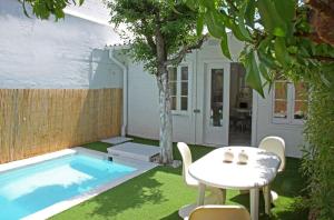 un patio con mesa y sillas junto a una piscina en Villa Alba, en Barcelona