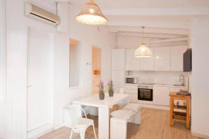 cocina blanca con mesa blanca y sillas en Villa Alba, en Barcelona