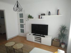 una sala de estar con TV de pantalla plana en un armario blanco en El Apartamento de Marta en A Coruña