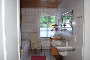 a bathroom with a sink and a toilet and a tub at Gästehaus Beurener Mühle in Bad Bertrich