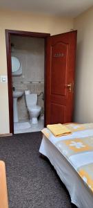 a bathroom with a bed and a toilet and a door at pokoje gościnne Grażyna in Cieszyn