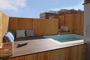 bañera de hidromasaje en una terraza con una valla de madera en Fridays Flats Casa Lemonade, en Hospitalet de Llobregat
