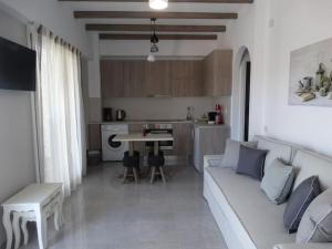 a living room with a couch and a kitchen at Skopelitis Village in Katapola