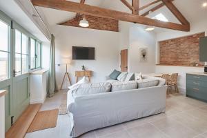 a living room with a white couch and a table at Orchard View Cottage in Yedingham