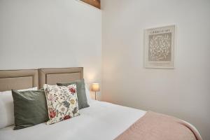 a bedroom with a white bed with pillows at Orchard View Cottage in Yedingham