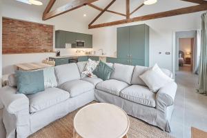 a living room with a white couch and a kitchen at Orchard View Cottage in Yedingham