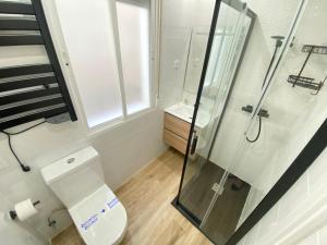 a bathroom with a toilet and a glass shower at Piso Lacy Ile in Madrid