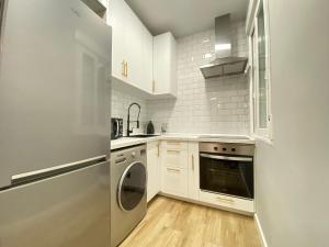 a kitchen with white cabinets and a dishwasher at Piso Lacy Ile in Madrid