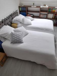 2 camas en una habitación con sábanas y almohadas blancas en Chambre d'hote chez Maud, en Saint-Sauveur-Marville
